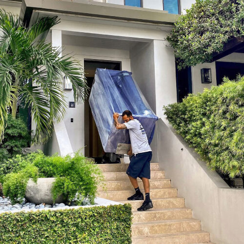 Corporate Relocation Movers Servicing Tampa FL Employee of Tampa-based Corporate Relocation Mover Lifting a Sofa