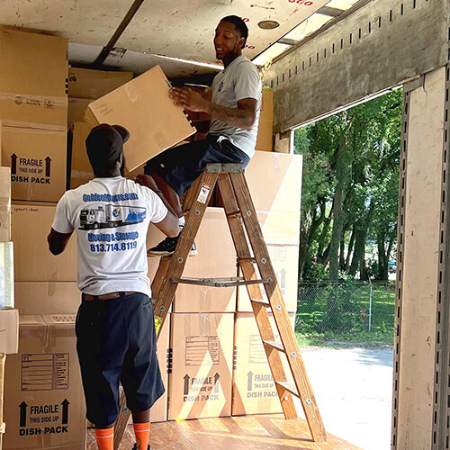 Employees of a Moving Company Servicing Ellenton FL Stacking Boxes Inside Their Truck
