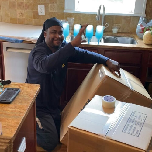 Employee of a Moving Company Packing Boxes for Family Moving to Land O Lakes FL