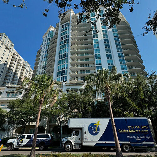 Moving Company Servicing Naples Florida Vehicles of Moving Company Servicing Naples FL Parked In Front of a Tall Building