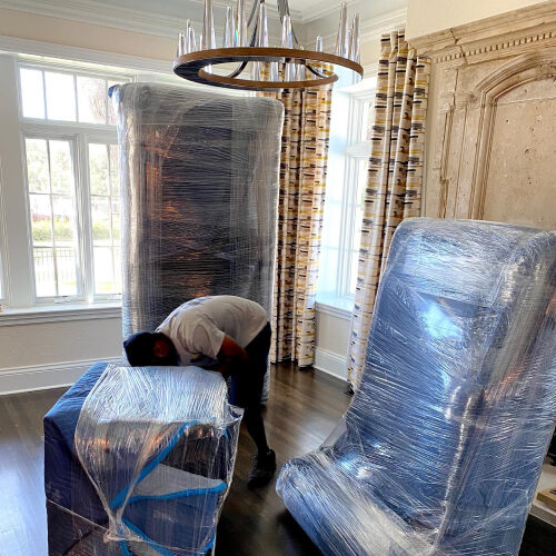 Mover Wrapping Furniture Before Loading To Moving Company Truck Bound For Palm Harbor Florida