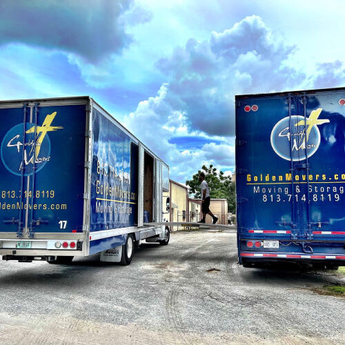 Mover Walking Between Two Trucks Owned by Top Moving Company in Pinellas Park Florida