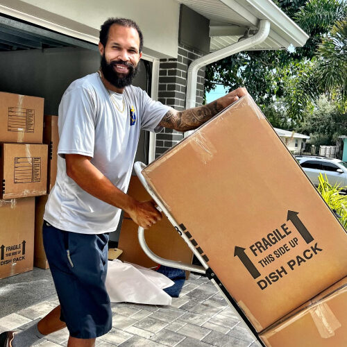 Mover Walking Between Two Trucks Owned by Top Moving Company in Pinellas Park Florida
