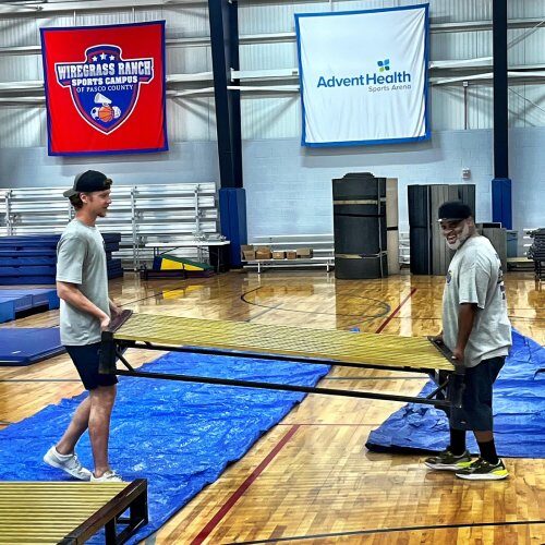 Two Moving Company Employees in Wesley Chapel FL Carrying a Heavy Furniture