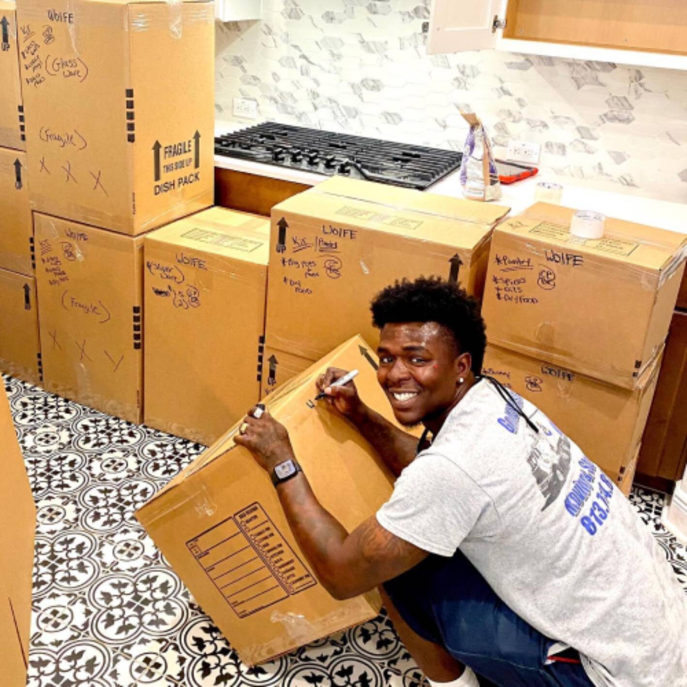 Moving Company in Miami FL Miami Man Working For Top Moving Company Writing Labels in Moving Boxes