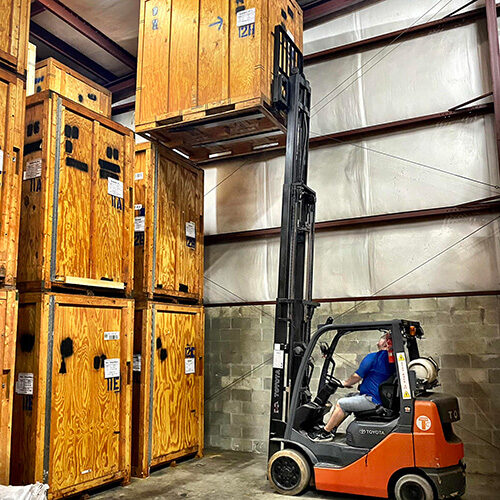 Moving and Storage Company in Tampa FL Tampa Employee of Moving and Storage Company Using Machine To Lift Storage Crate